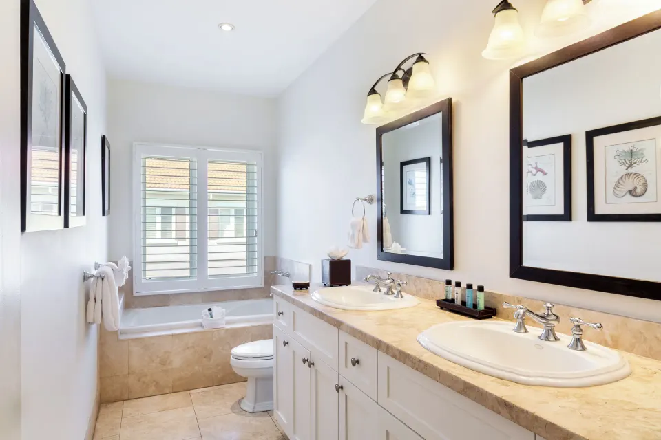 Luxury Penthouse bathroom with double vanity and shuttered window at Villa del Mar.