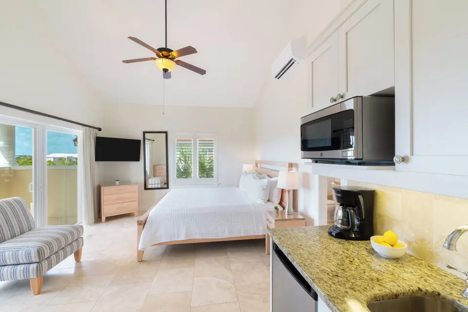 Luxury Penthouse bedroom with kitchenette and balcony doors at Villa del Mar.
