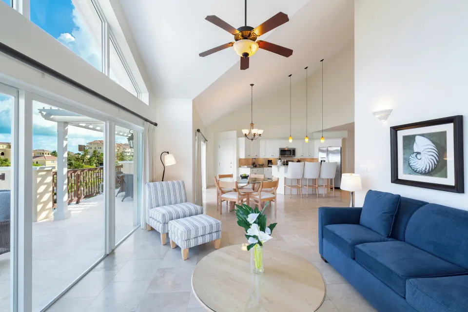 Luxury Penthouse living room with blue sofa and balcony doors at Villa del Mar.
