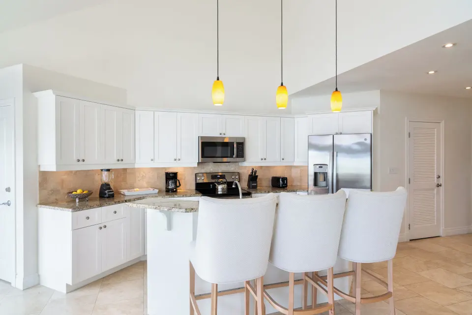 Luxury Suite kitchen with three bar chairs and pendant lights at Villa del Mar.