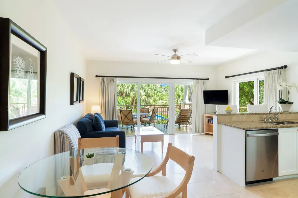 Luxury Suite living area with sofa, dining table, kitchen, and balcony at Villa del Mar.