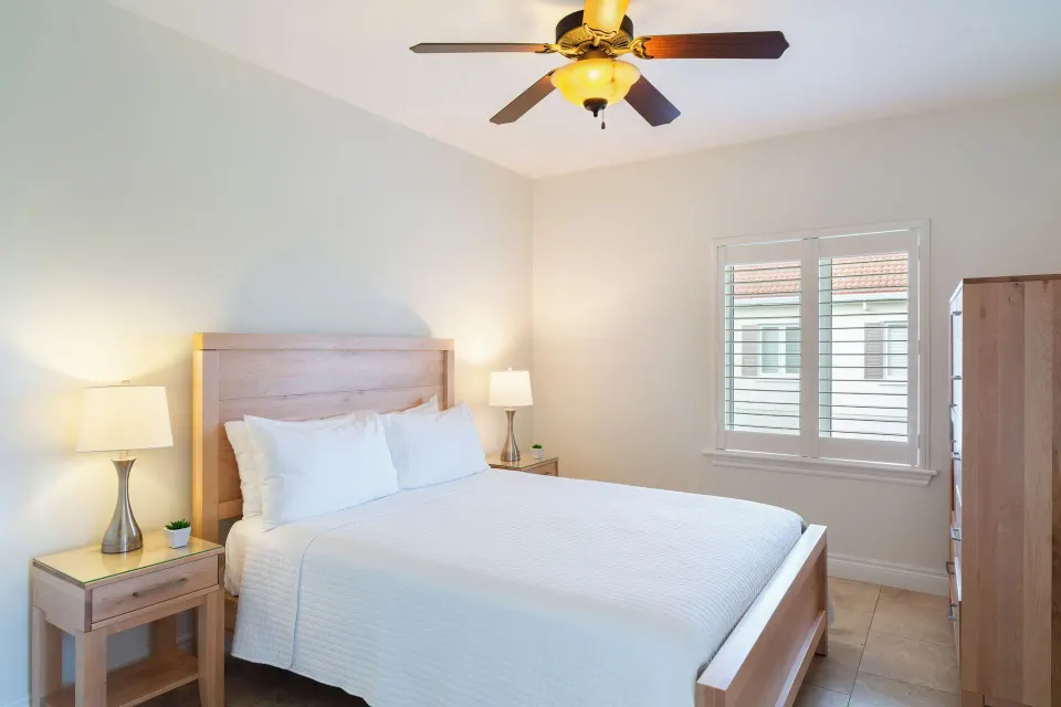 Luxury Suite two-bedroom guest room with a queen bed and shutters at Villa del Mar.