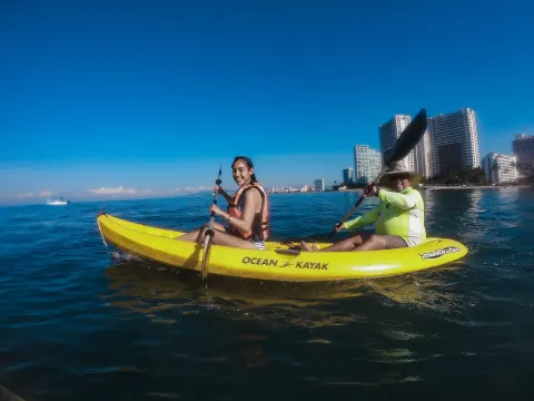 Two guests paddle a yellow kayak offshore at Villa del Palmar Beach Resort and Spa, Puerto Vallarta.