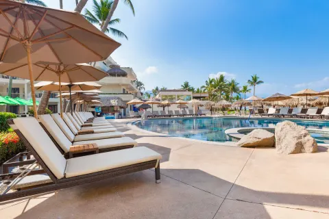 Poolside loungers and umbrellas at Villa del Palmar Beach Resort and Spa, Puerto Vallarta.