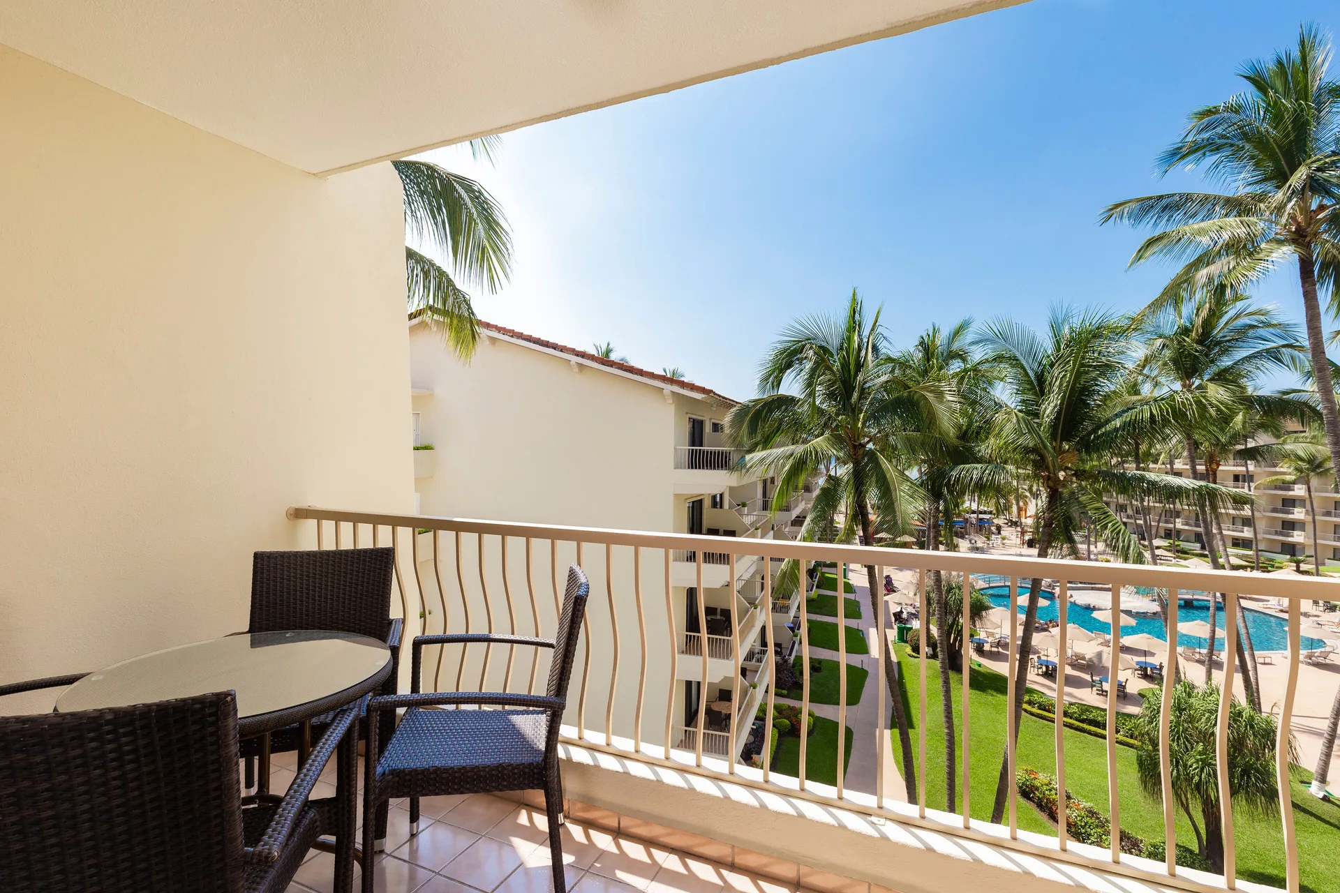 Junior Suite balcony with pool and palms at Villa del Palmar Beach Resort and Spa, Puerto Vallarta.