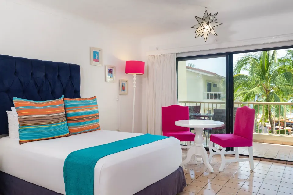 Junior Suite bed beside balcony doors at Villa del Palmar Beach Resort and Spa, Puerto Vallarta.