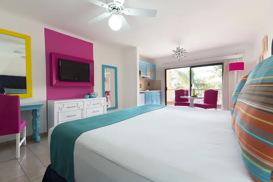 Junior Suite king bed with TV and kitchenette at Villa del Palmar Beach Resort and Spa, Puerto Vallarta.