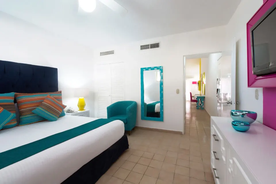 Superior Two Bedroom Suite bedroom with teal chair at Villa del Palmar Beach Resort and Spa, Puerto Vallarta.