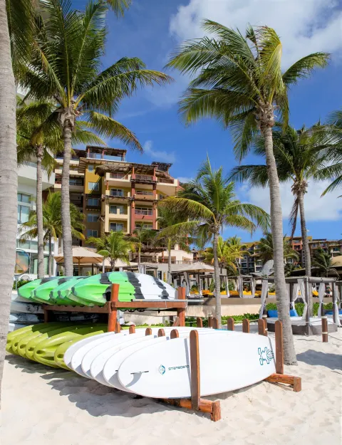 Beach activity boards beneath palms at Villa del Palmar Cancun Beach Resort & Spa.