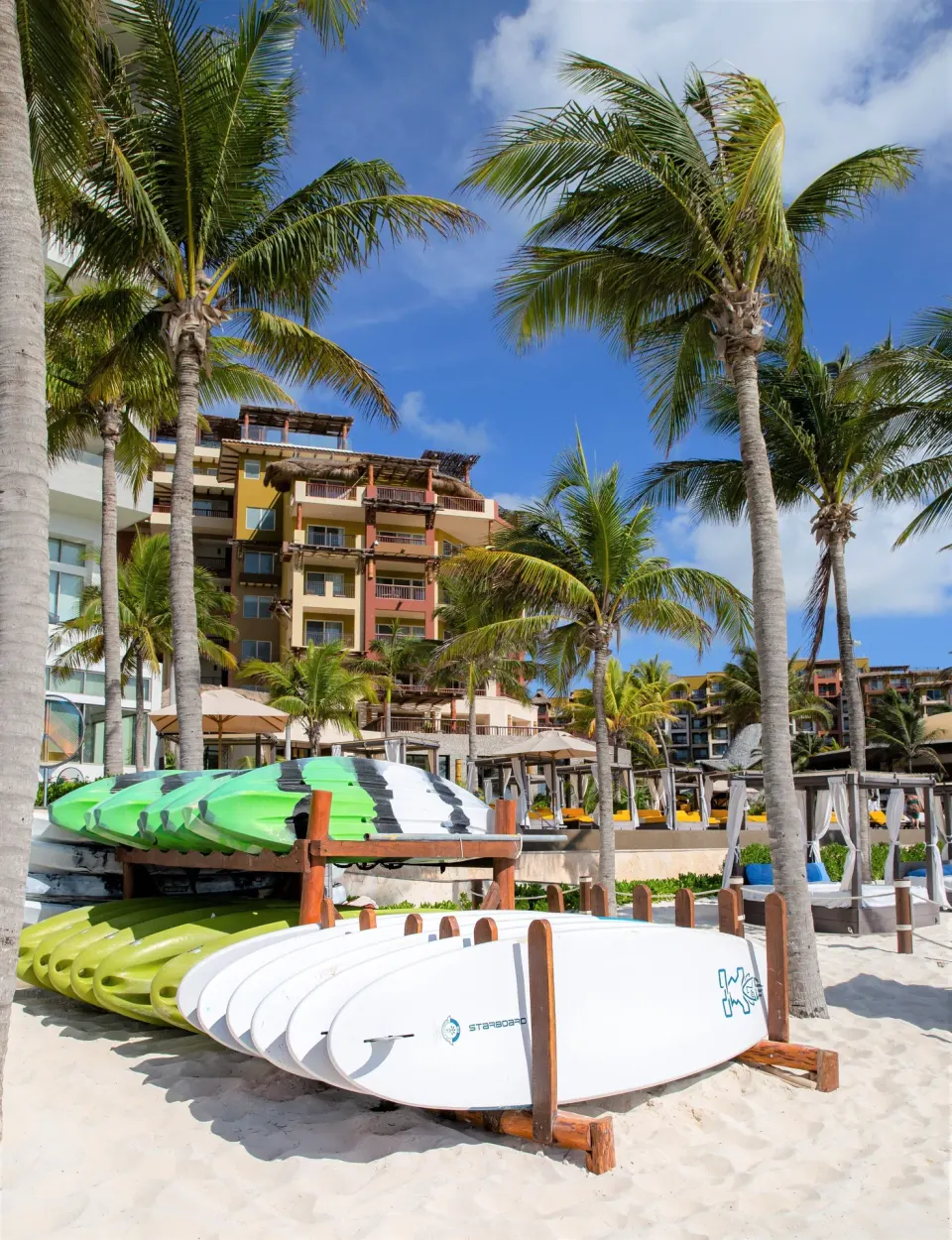 Beach activity boards beneath palms at Villa del Palmar Cancun Beach Resort & Spa.