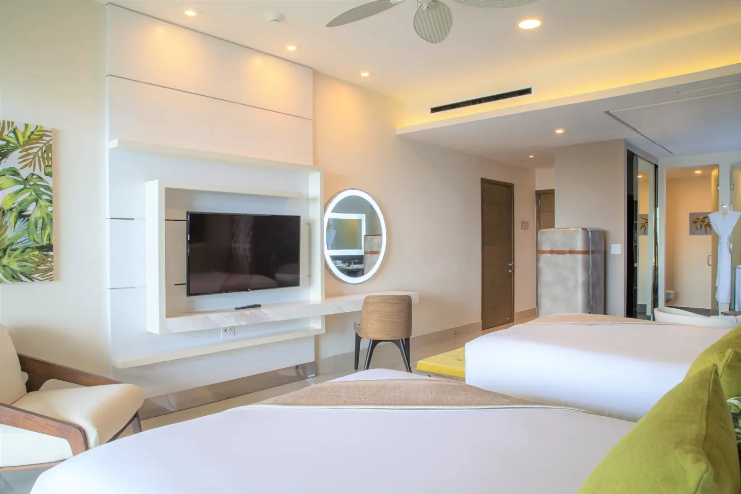 Guest room with two beds and media wall at Villa del Palmar Cancun Beach Resort & Spa.