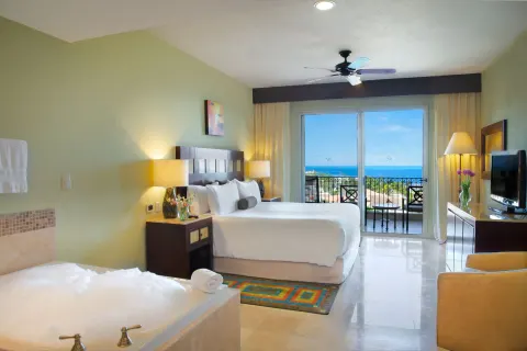 One Bedroom Ocean View king bed and in-room tub at Villa del Palmar Cancun Beach Resort & Spa.