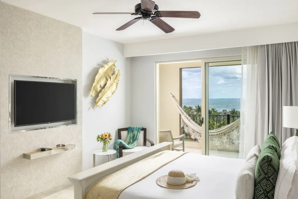 One Bedroom Ocean View king bedroom with TV and hammock at Villa del Palmar Cancun Beach Resort & Spa.