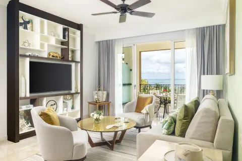 One Bedroom Ocean View living room with sofa and balcony at Villa del Palmar Cancun Beach Resort & Spa.