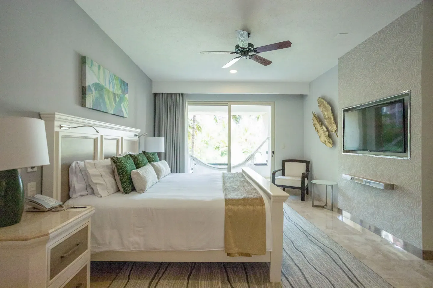 One Bedroom suite with white bed and balcony hammock at Villa del Palmar Cancun Beach Resort & Spa.