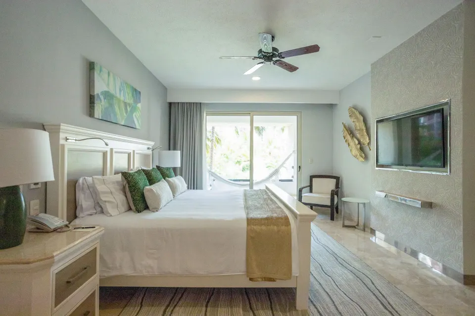 One Bedroom suite with white bed and balcony hammock at Villa del Palmar Cancun Beach Resort & Spa.