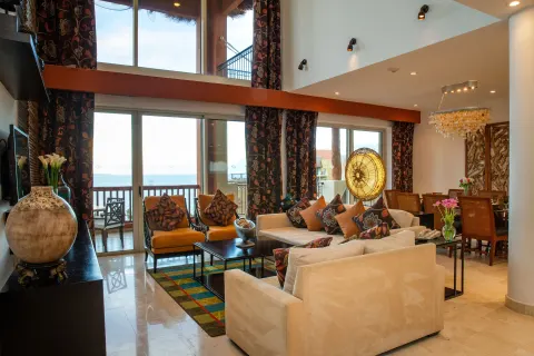 Three Bedroom Loft living room with double-height windows at Villa del Palmar Cancun Beach Resort & Spa.