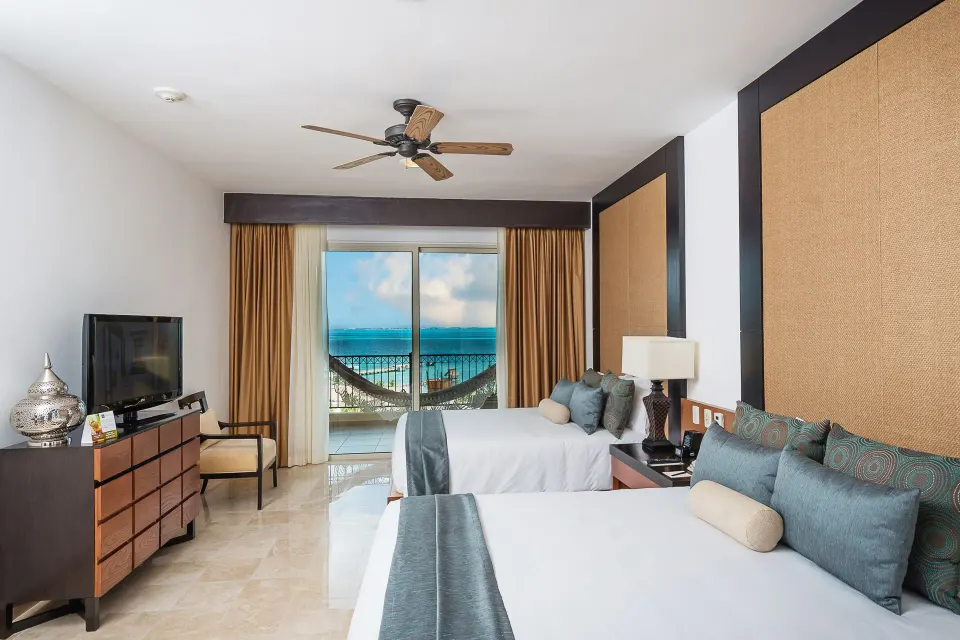 Three Bedroom Loft bedroom with two beds and balcony view at Villa del Palmar Cancun Beach Resort & Spa.