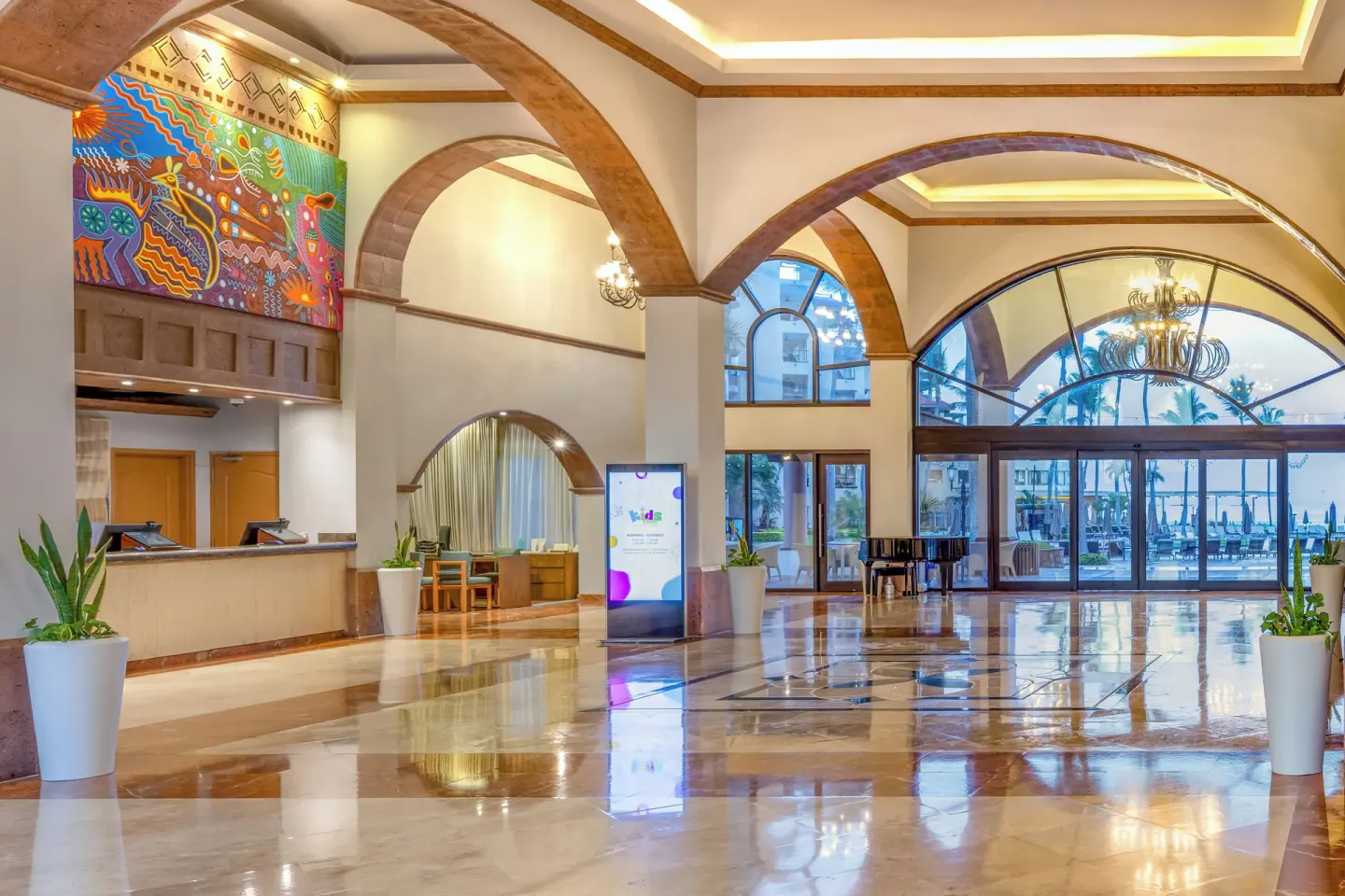 Arched lobby with reception desk and pool views at Villa Del Palmar Flamingos Beach Resort and Spa.
