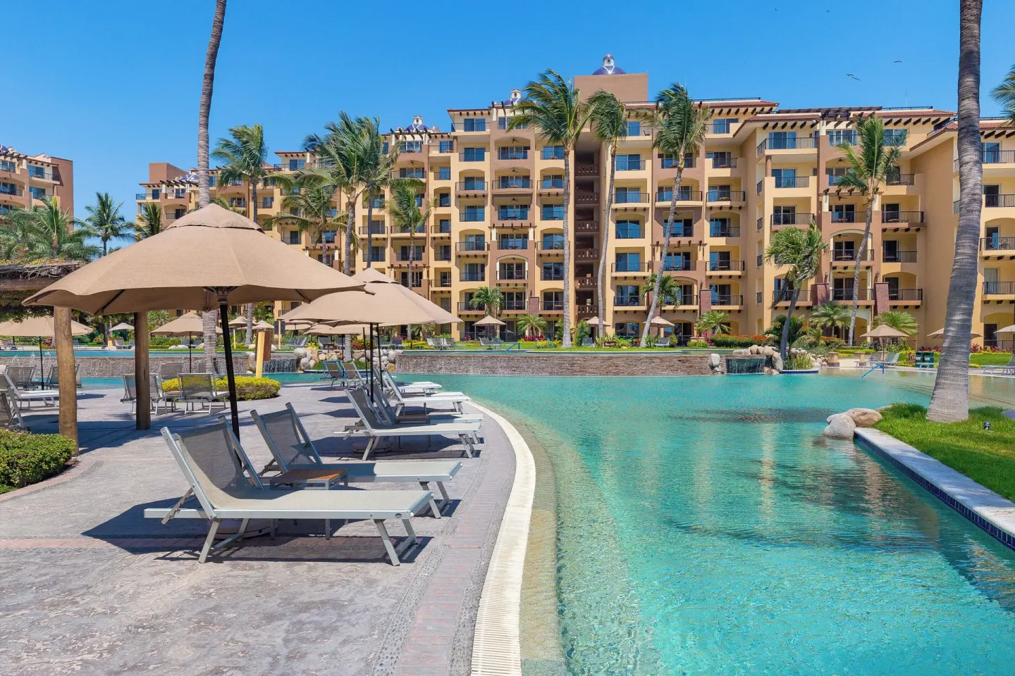 Curved pool deck with loungers at Villa Del Palmar Flamingos Beach Resort and Spa