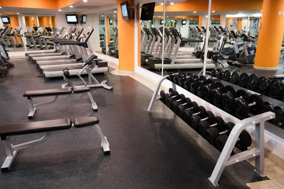 Dumbbell rack, benches, and treadmills in the gym at Villa Del Palmar Flamingos Beach Resort and Spa.