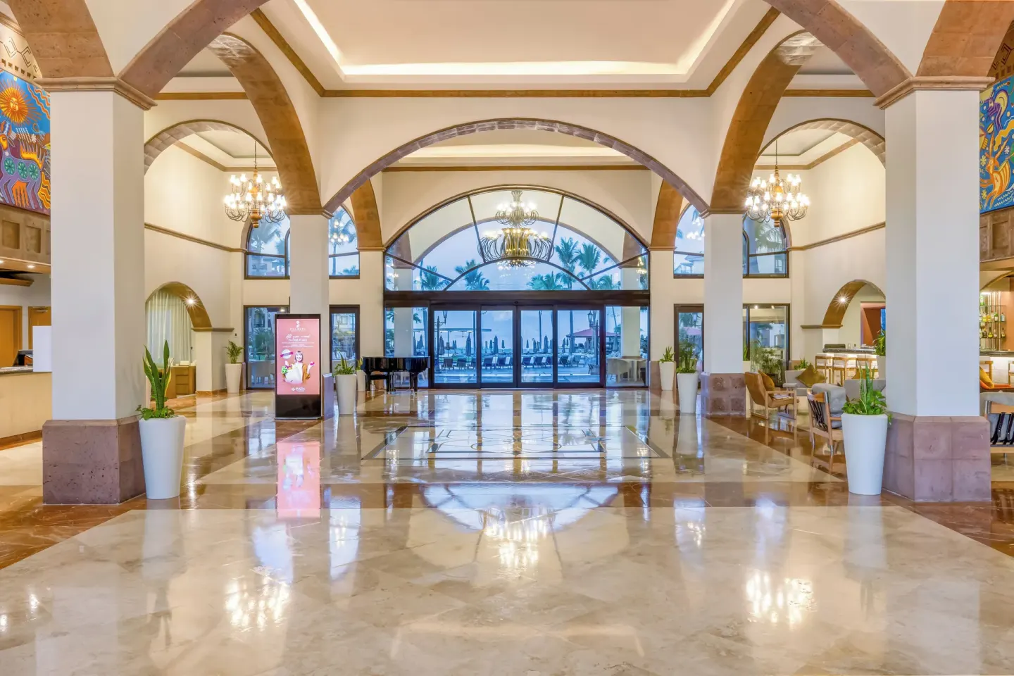 Grand lobby hall with chandeliers and glass doors at Villa Del Palmar Flamingos Beach Resort and Spa.