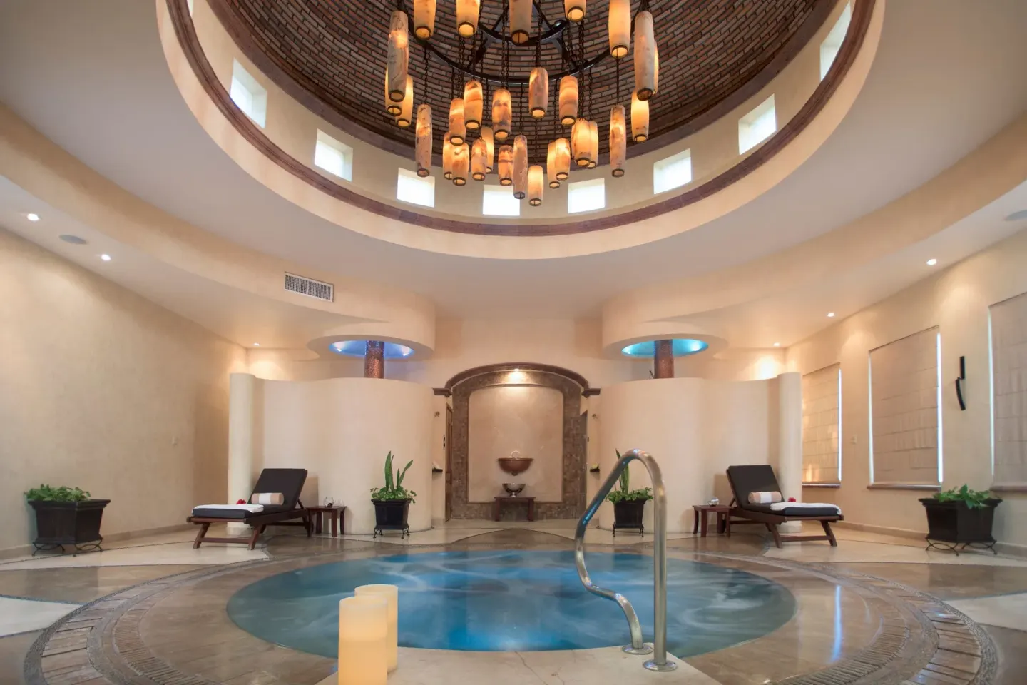 Indoor spa pool beneath a round chandelier at Villa Del Palmar Flamingos Beach Resort and Spa.