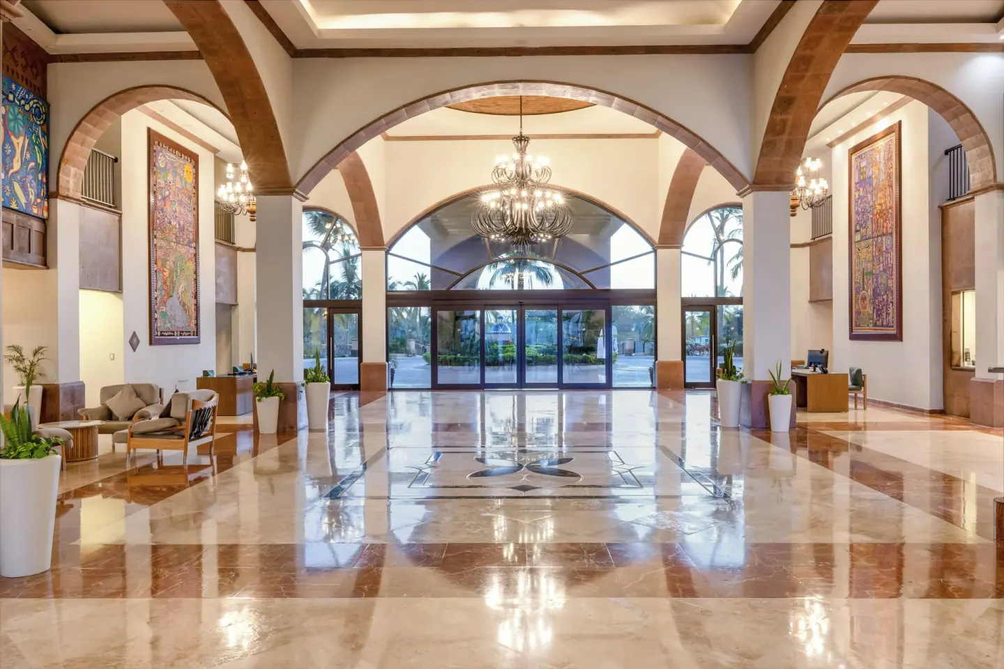 Lobby entrance hall with chandeliers and arched windows at Villa Del Palmar Flamingos Beach Resort and Spa.