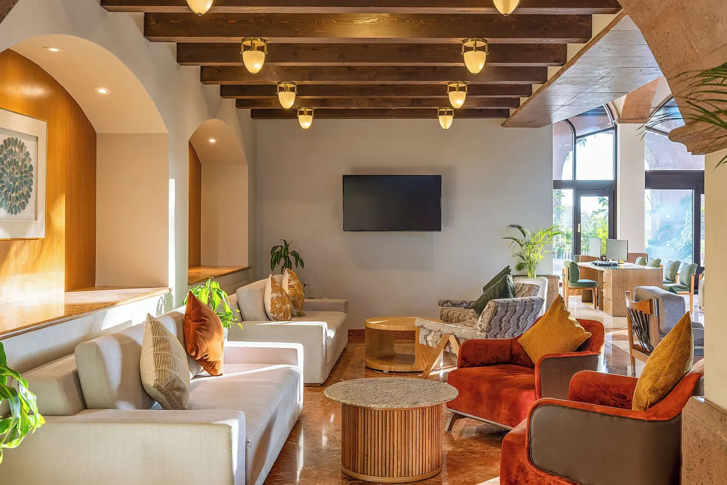 Lobby lounge with sofas, tables, and TV at Villa Del Palmar Flamingos Beach Resort and Spa.