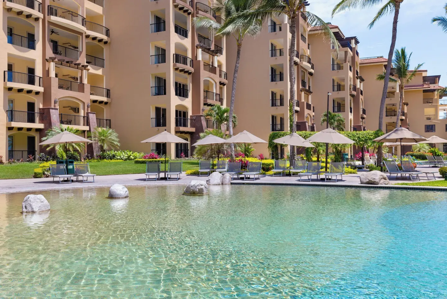 Quiet pool edge with umbrellas at Villa Del Palmar Flamingos Beach Resort and Spa
