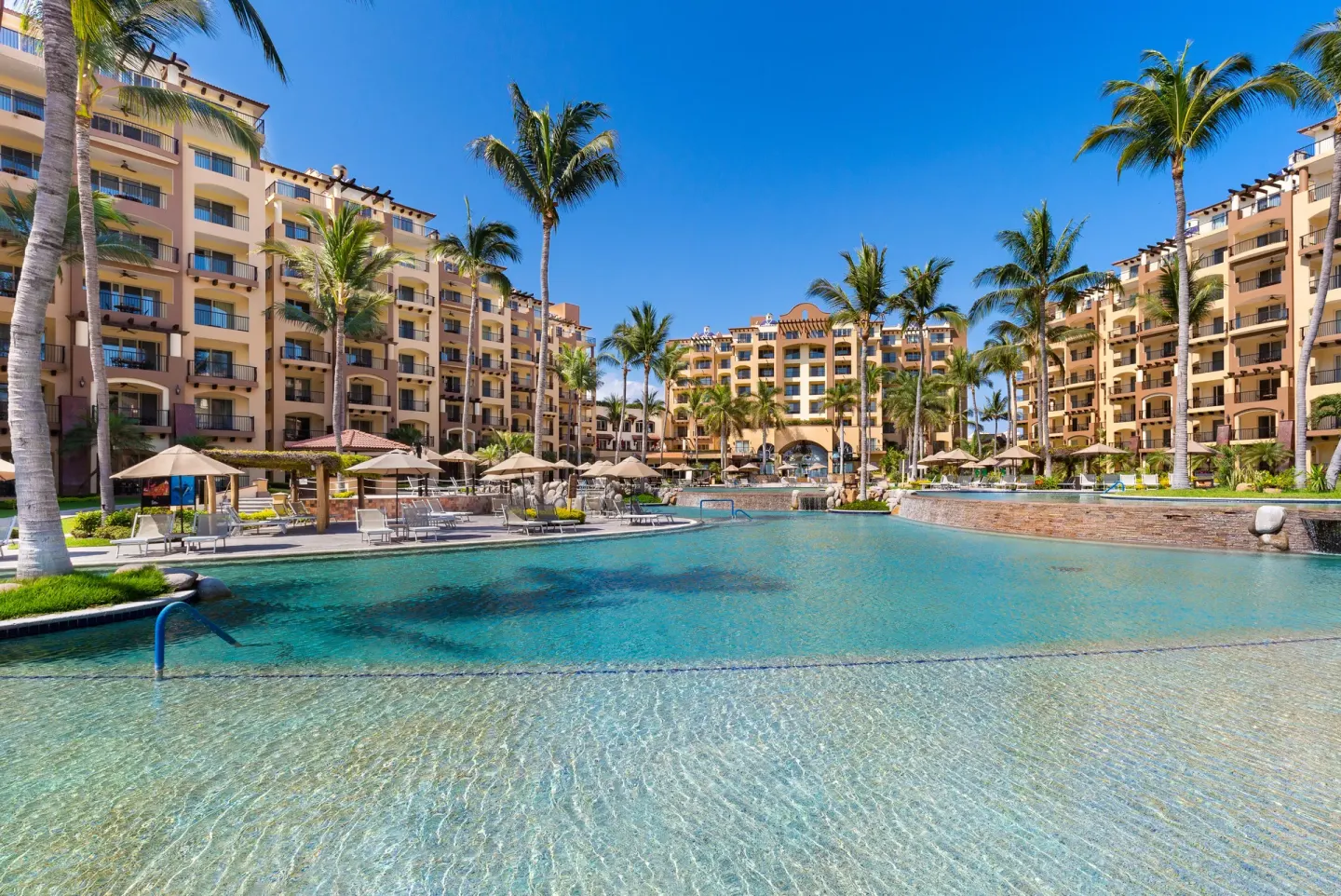 Resort pool courtyard with palms and balconies at Villa Del Palmar Flamingos Beach Resort and Spa.
