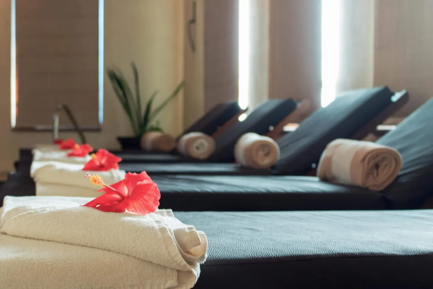 Spa lounge chairs with towels and hibiscus flowers at Villa Del Palmar Flamingos Beach Resort and Spa.