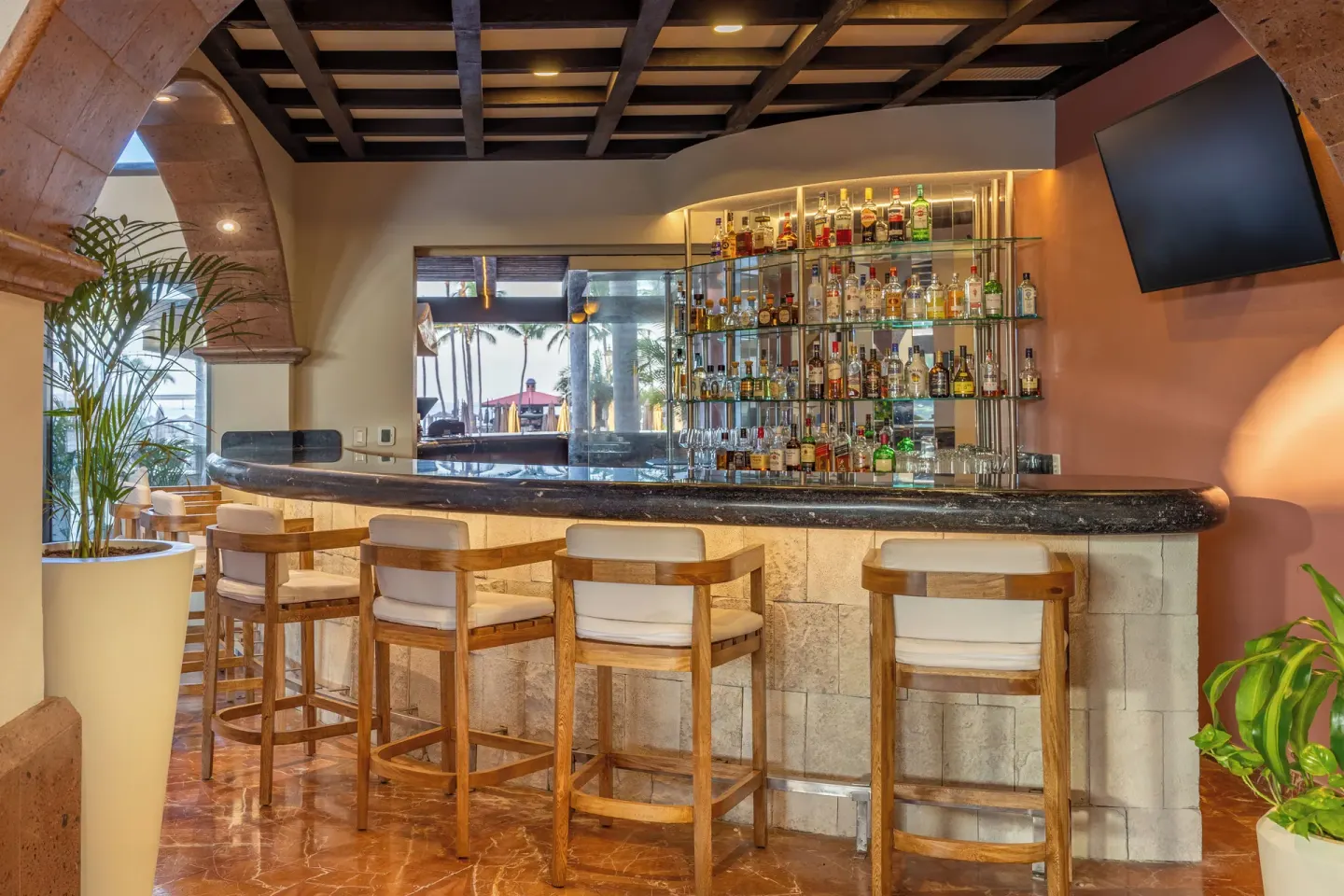 Marble bar with high stools and bottle shelving at Villa Del Palmar Flamingos Beach Resort and Spa.