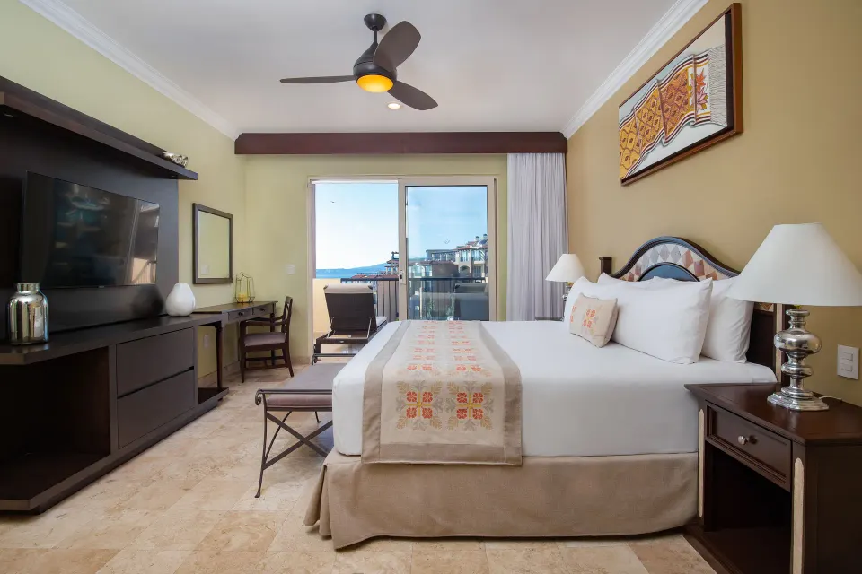 One Bedroom Suite king bed, TV wall, and balcony at Villa Del Palmar Flamingos Beach Resort and Spa.