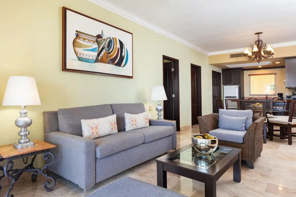 One Bedroom Suite living area with sofa and kitchen at Villa Del Palmar Flamingos Beach Resort and Spa.