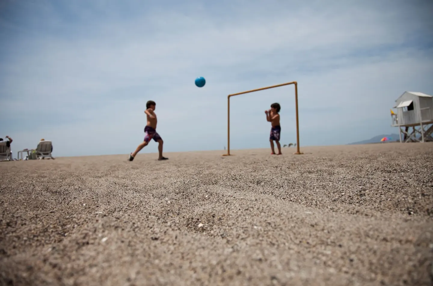 Children play ball on the sandy beach near a small goal at Villa Varadero.