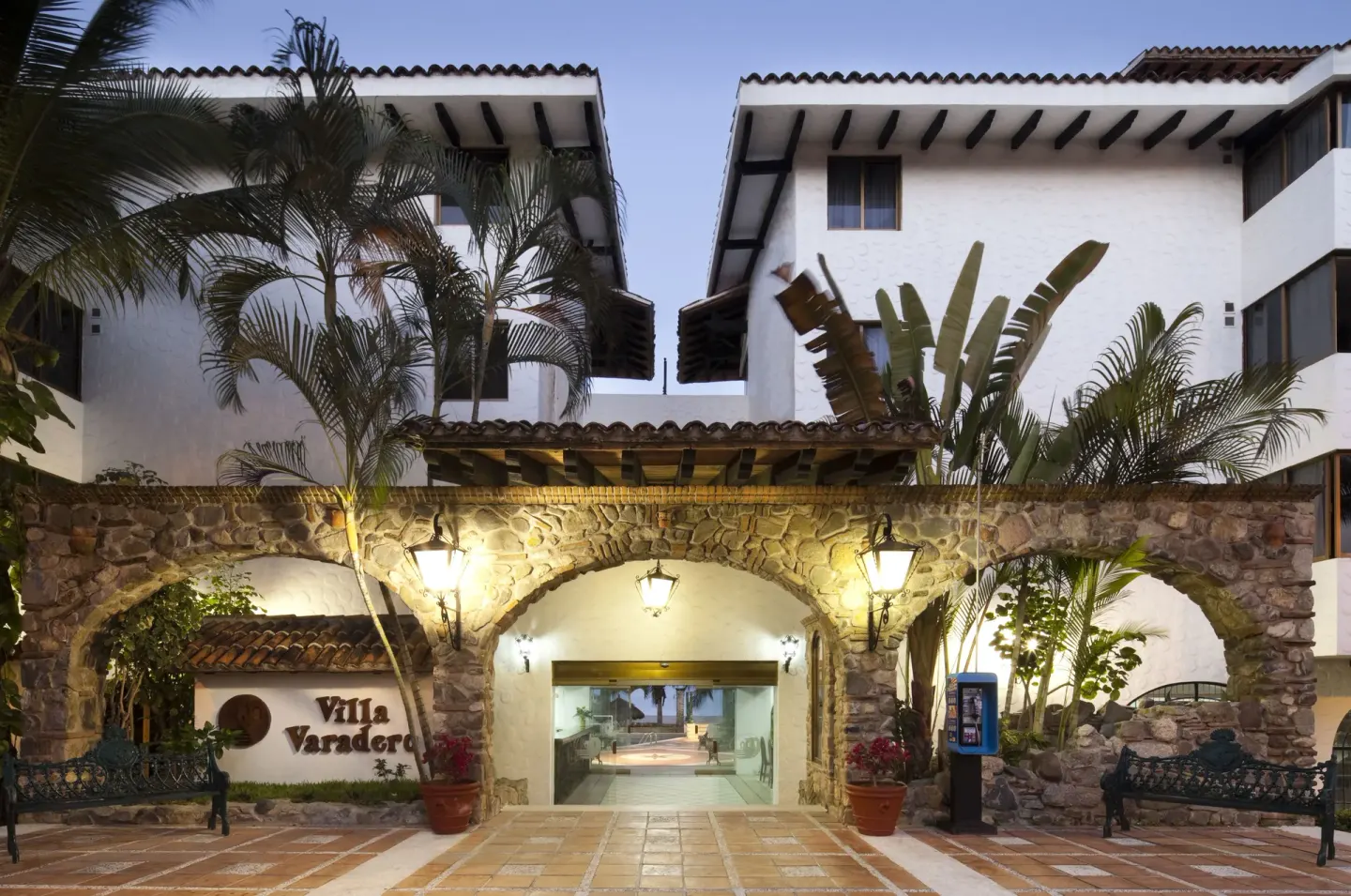 The Villa Varadero entrance is lit at dusk beneath stone arches and lanterns.