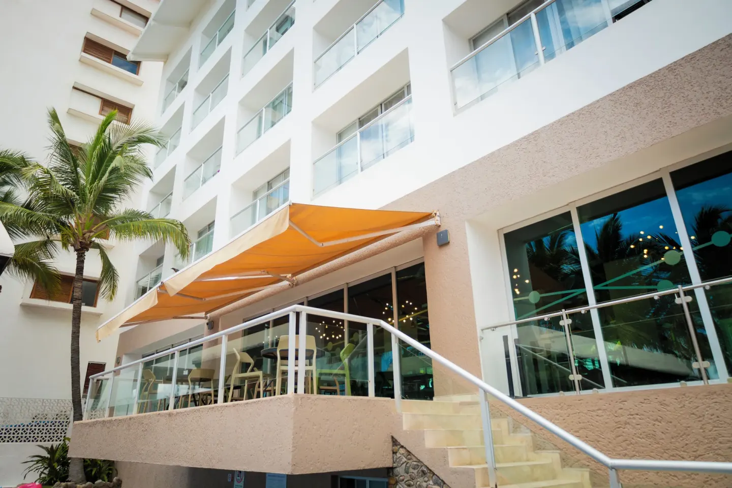 Exterior terrace at Villa Varadero with orange awnings and glass railings on the resort building.