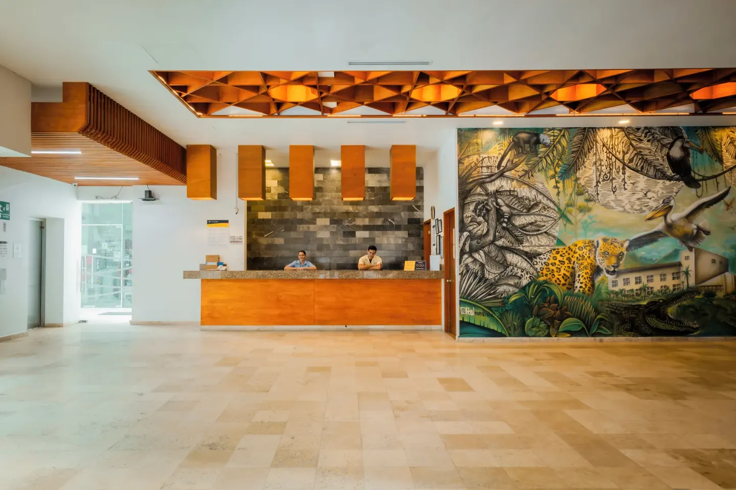 Wide lobby with reception desk and jungle mural artwork at Villa Varadero.