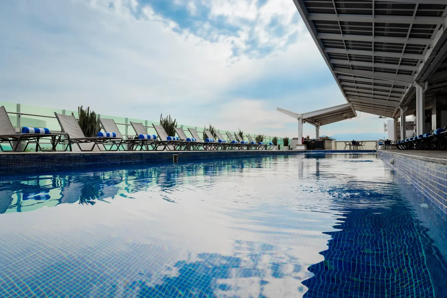 Long rooftop pool with rows of lounge chairs at Villa Varadero.