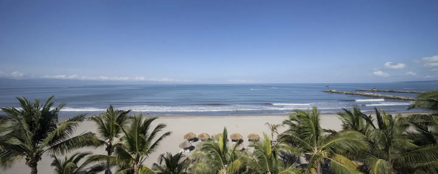 Panoramic beach, palms, and breakwater by Villa Varadero.