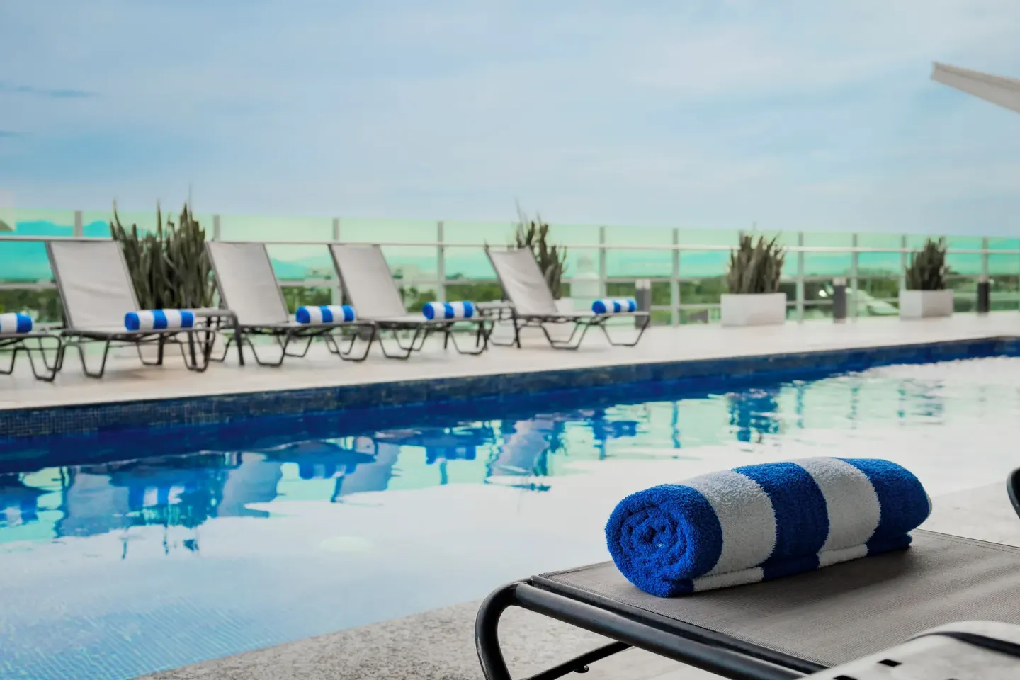 Rolled striped towel on a lounge chair by the pool at Villa Varadero.