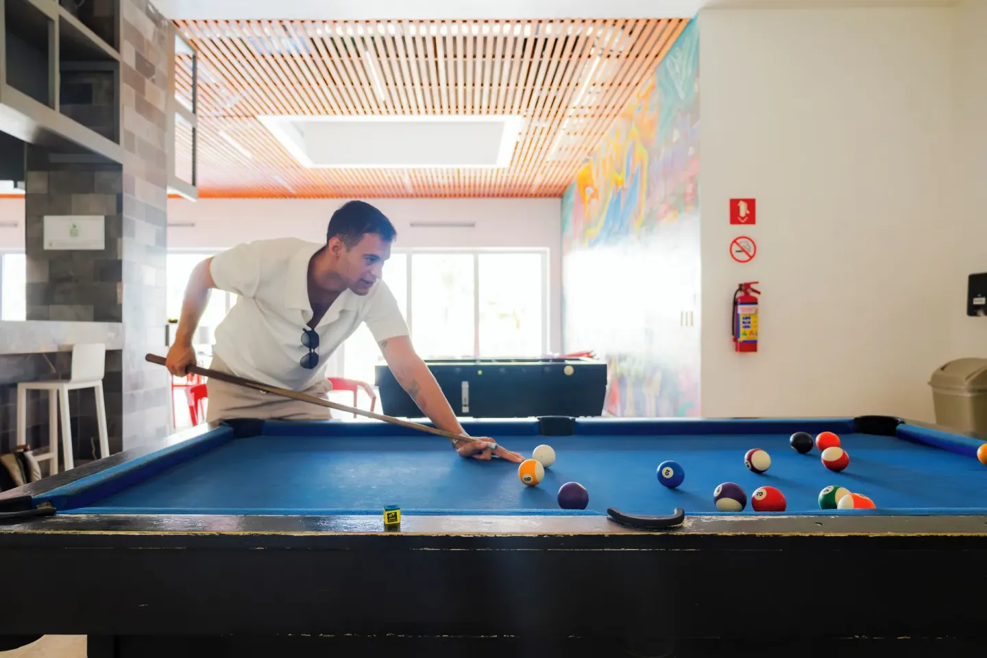 A guest lines up a shot on a blue pool table at Villa Varadero.