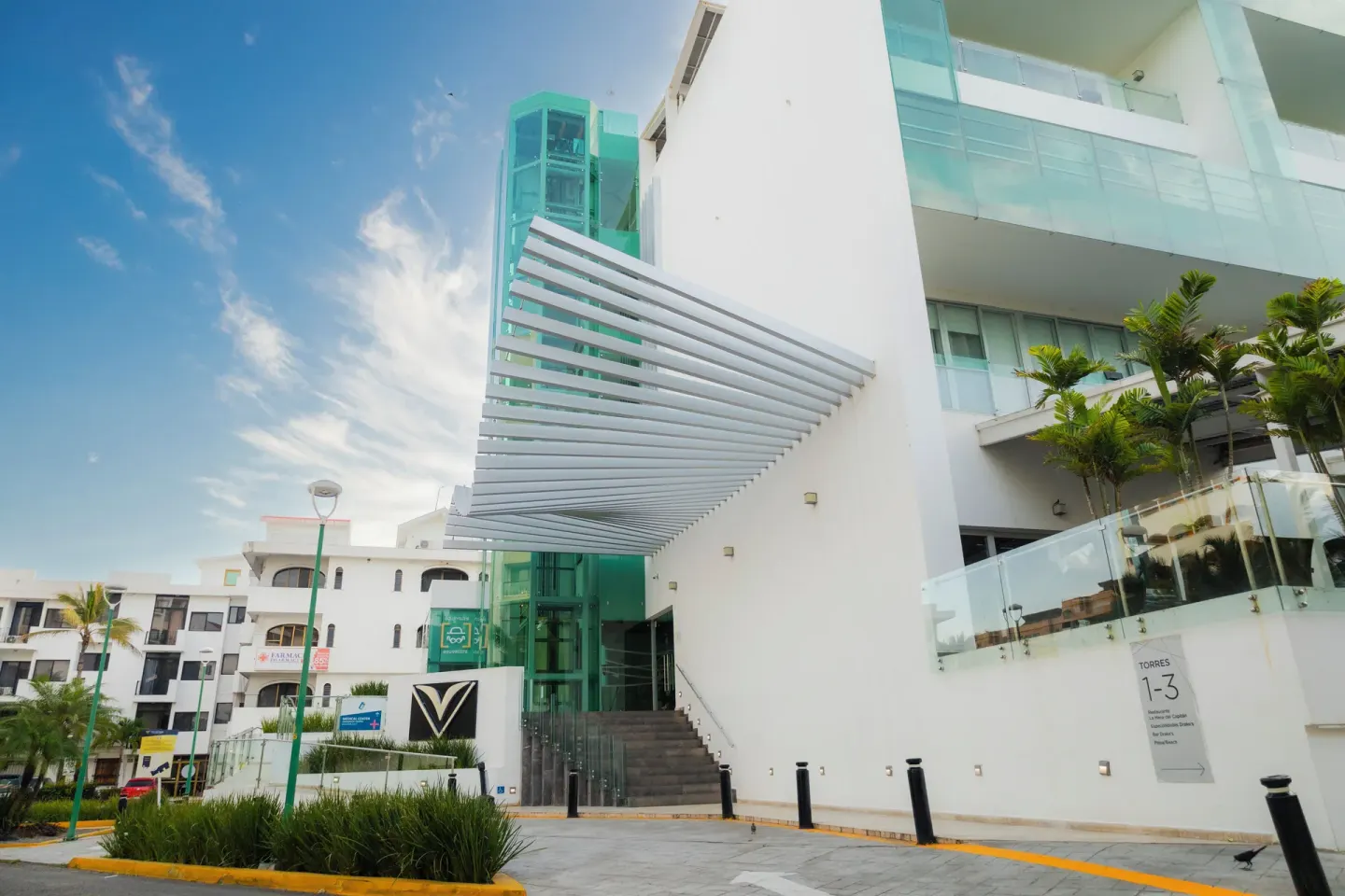 A side entrance with glass railings and a turquoise elevator tower at Villa Varadero.