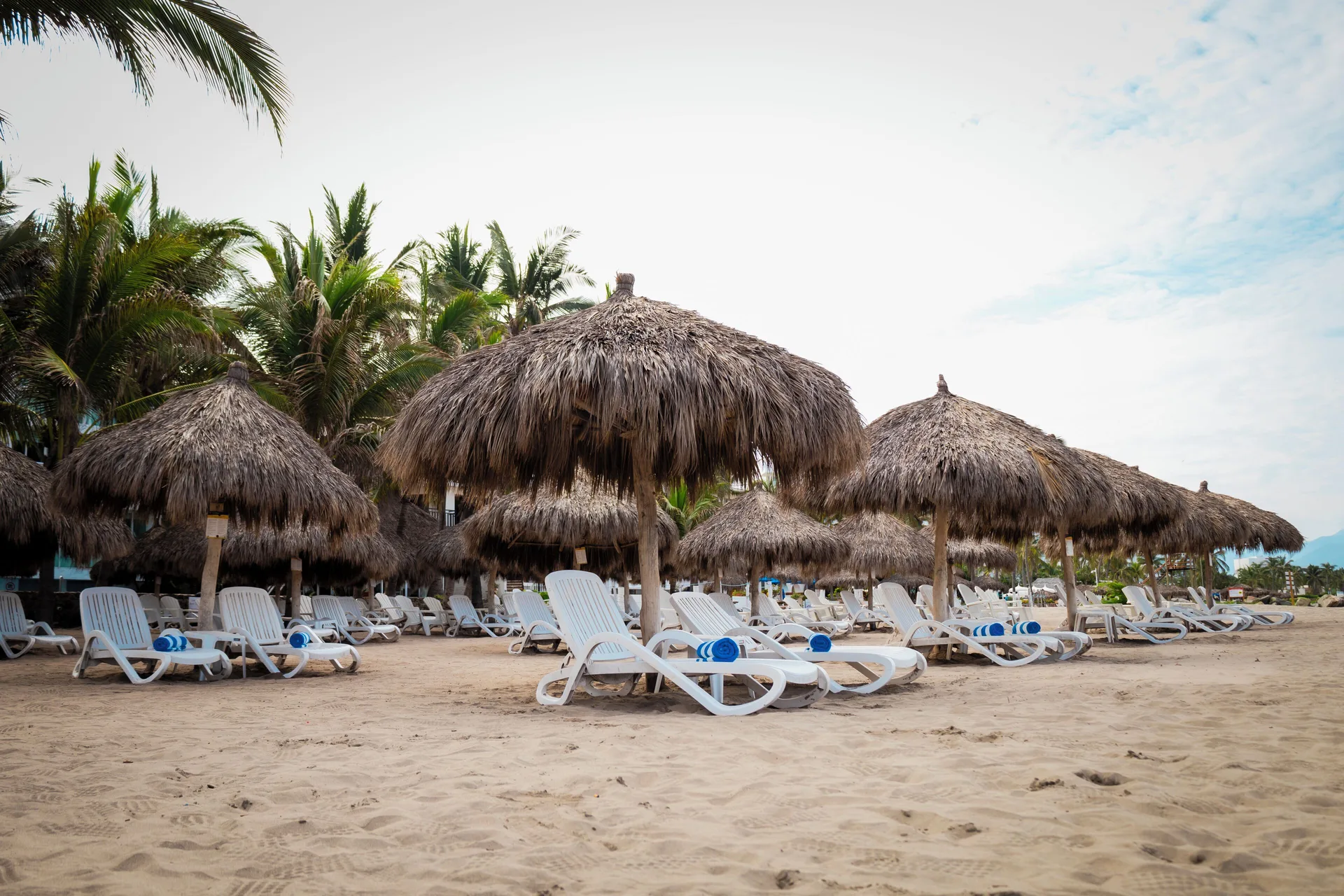 Thatched palapas and beach loungers on the sand at Villa Varadero.