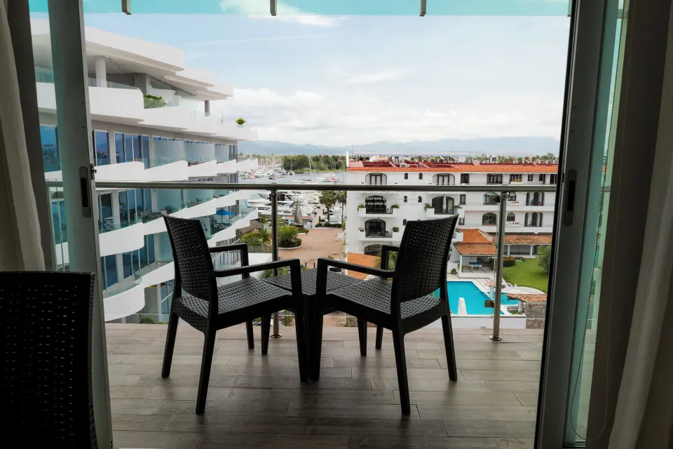 Balcony seating with marina, pool and neighboring buildings at Villa Varadero.