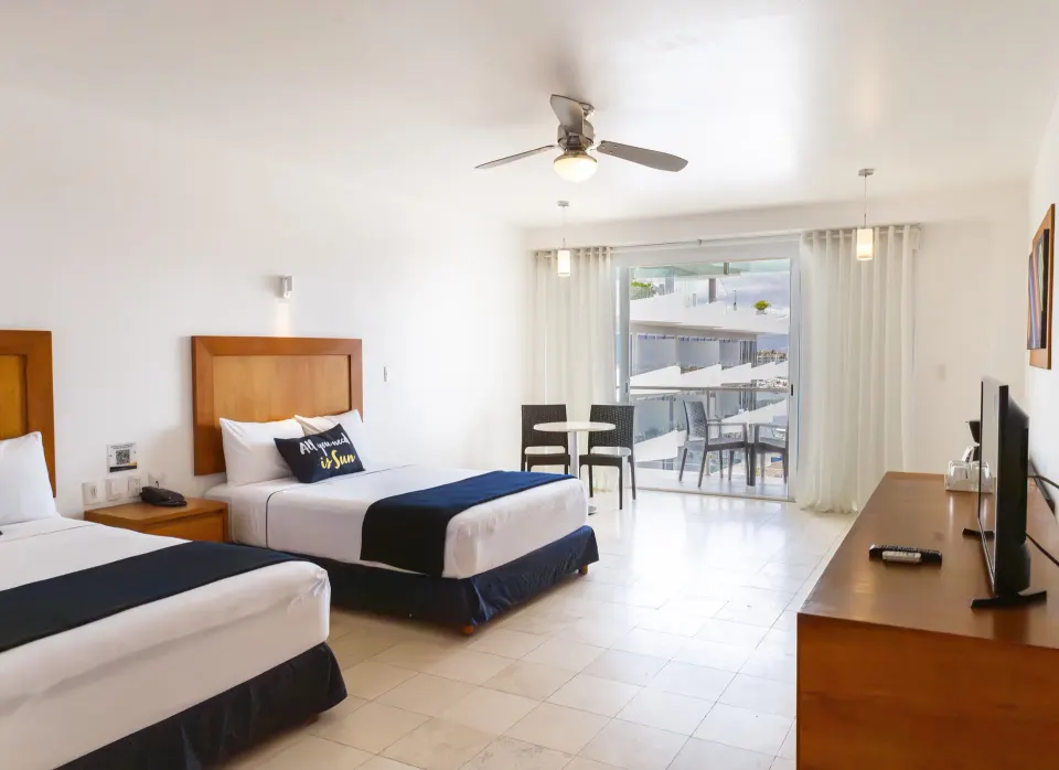 Deluxe room with two beds, balcony doors and TV at Villa Varadero.