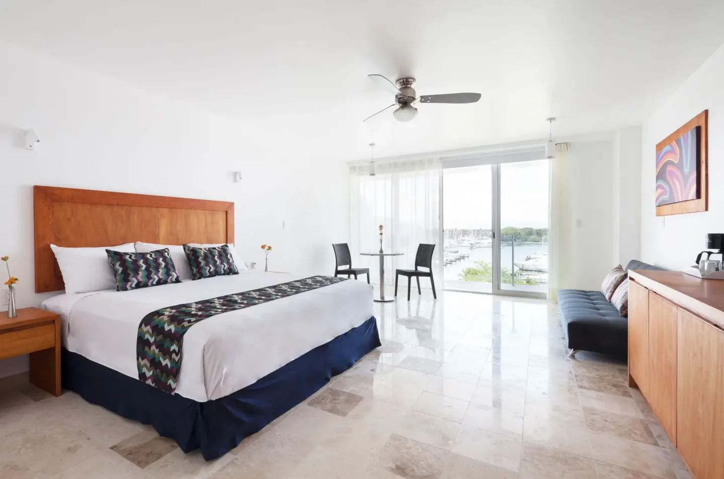 Deluxe Room with king bed, sofa, and sliding doors to a balcony at Villa Varadero.