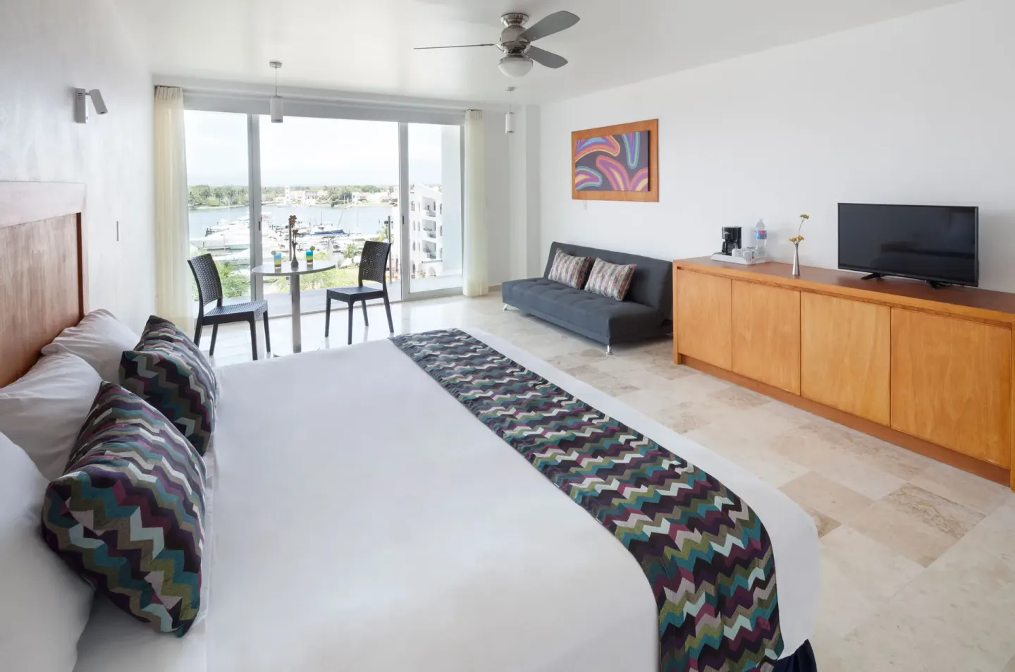 Deluxe Room with king bed and marina-facing balcony seating at Villa Varadero.