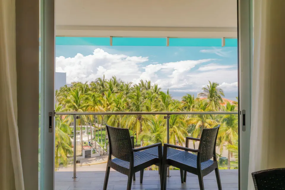 Balcony with two chairs overlooking palm trees at Villa Varadero.